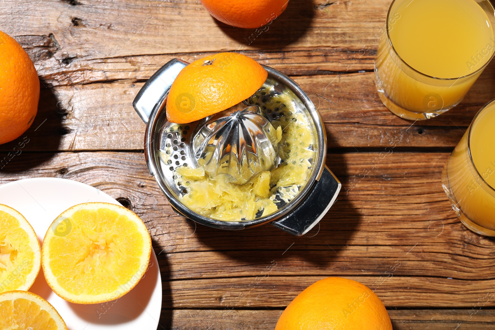 Freshly squeezed orange juice, fruits and juicer on wooden table, flat lay Photo of Freshly squeezed orange juice, fruits and juicer on wooden table, flat lay