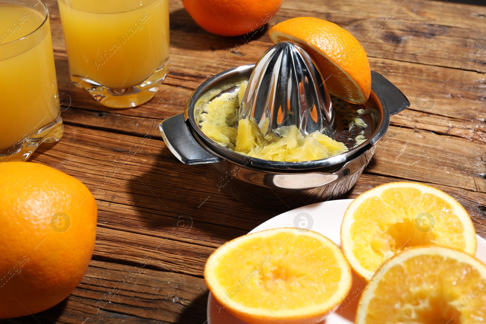 Freshly squeezed orange juice, fruits and juicer on wooden table, closeup Photo of Freshly squeezed orange juice, fruits and juicer on wooden table, closeup