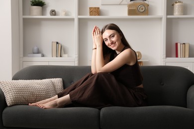 Photo of Beautiful woman sitting on sofa at home