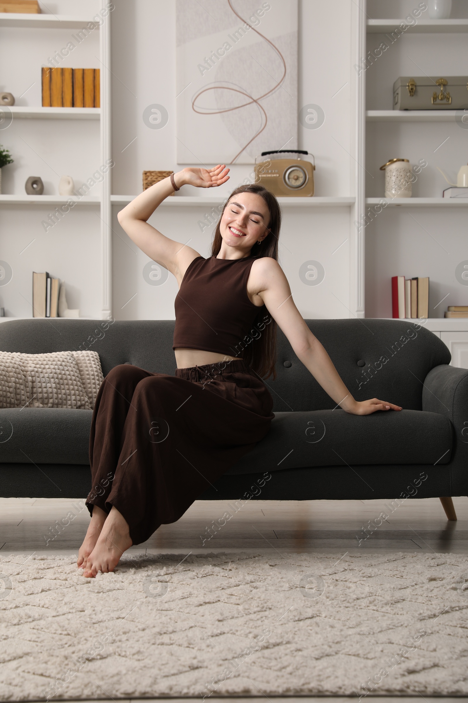 Photo of Beautiful woman sitting on sofa at home