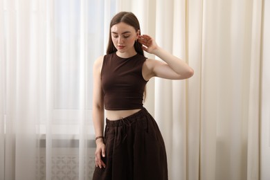 Photo of Beautiful woman posing near window at home