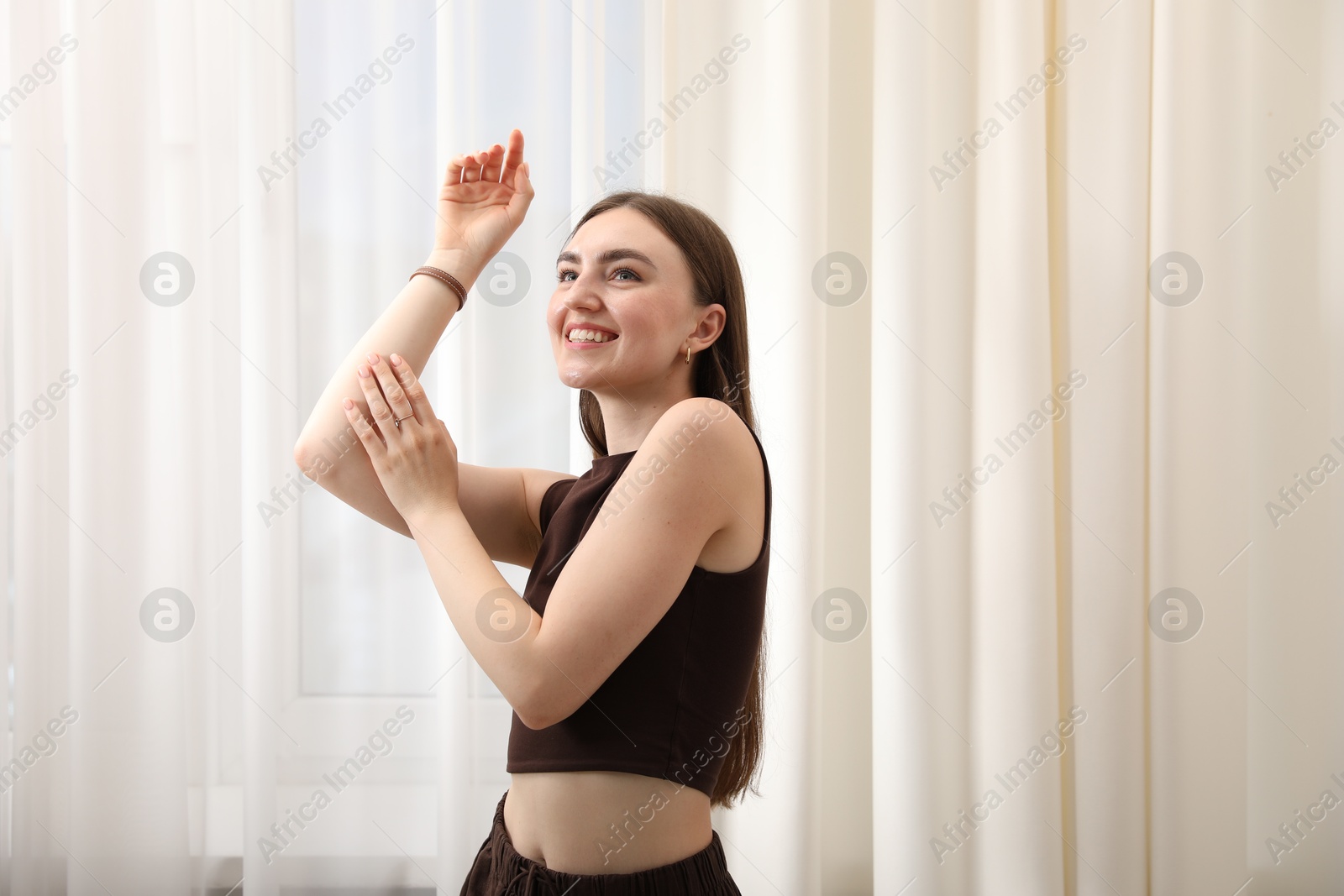 Photo of Beautiful woman posing near window at home