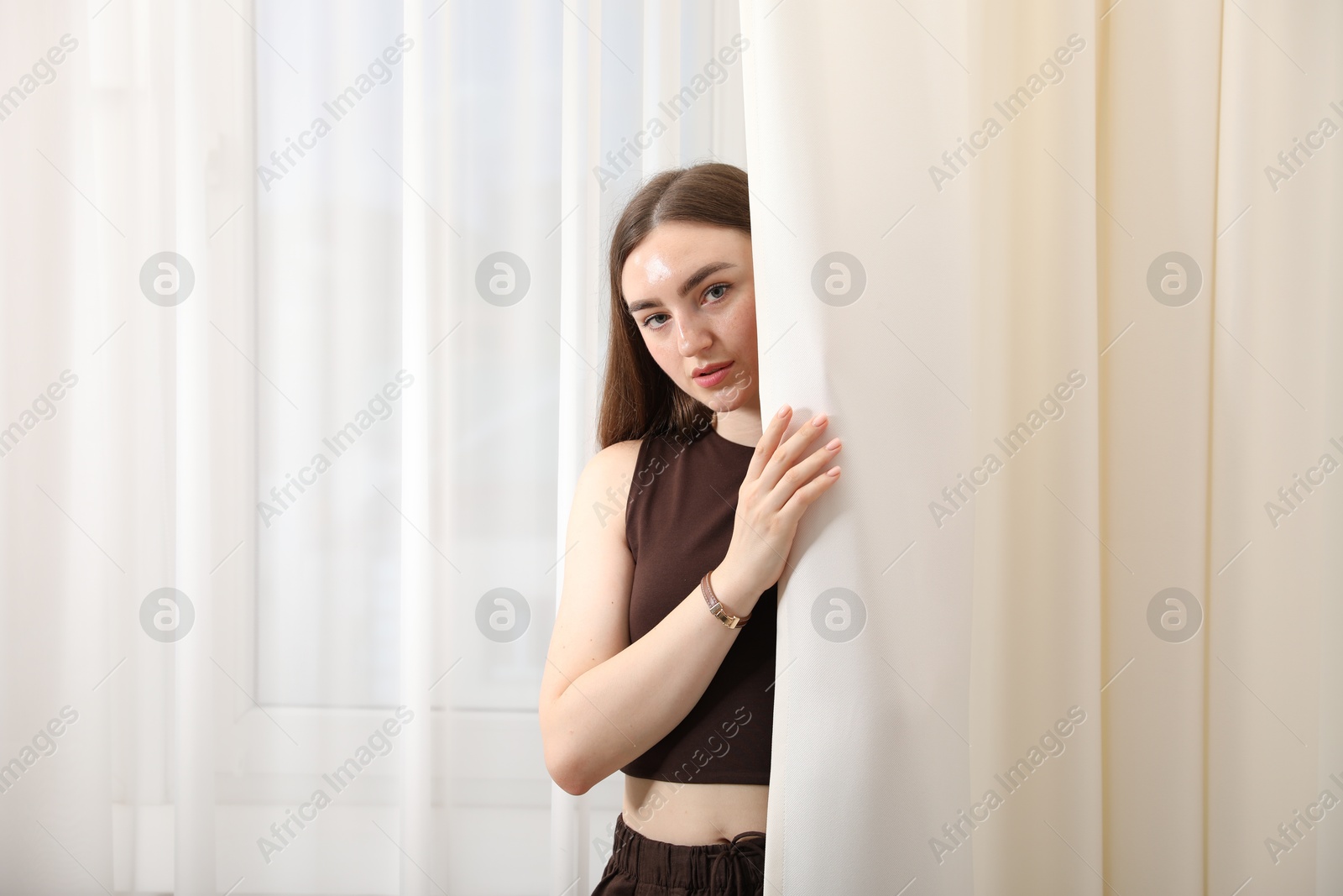 Photo of Beautiful woman posing near window at home