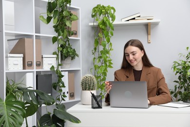 Photo of Woman having video chat via laptop at desk in office