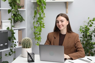 Photo of Woman working with laptop at desk in office