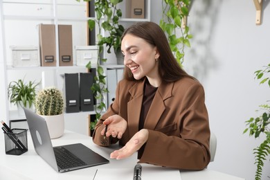 Photo of Woman having video chat via laptop at desk in office