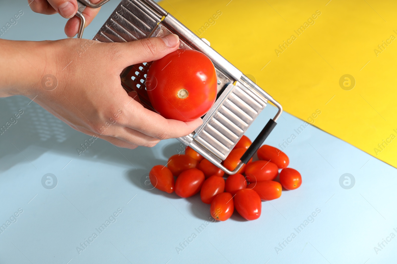 Photo of Woman with grater and tomatoes on color background, closeup