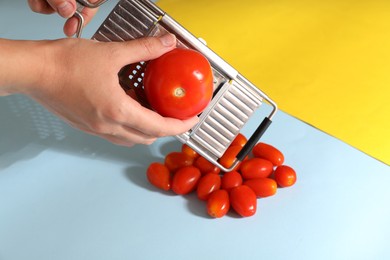 Photo of Woman with grater and tomatoes on color background, closeup