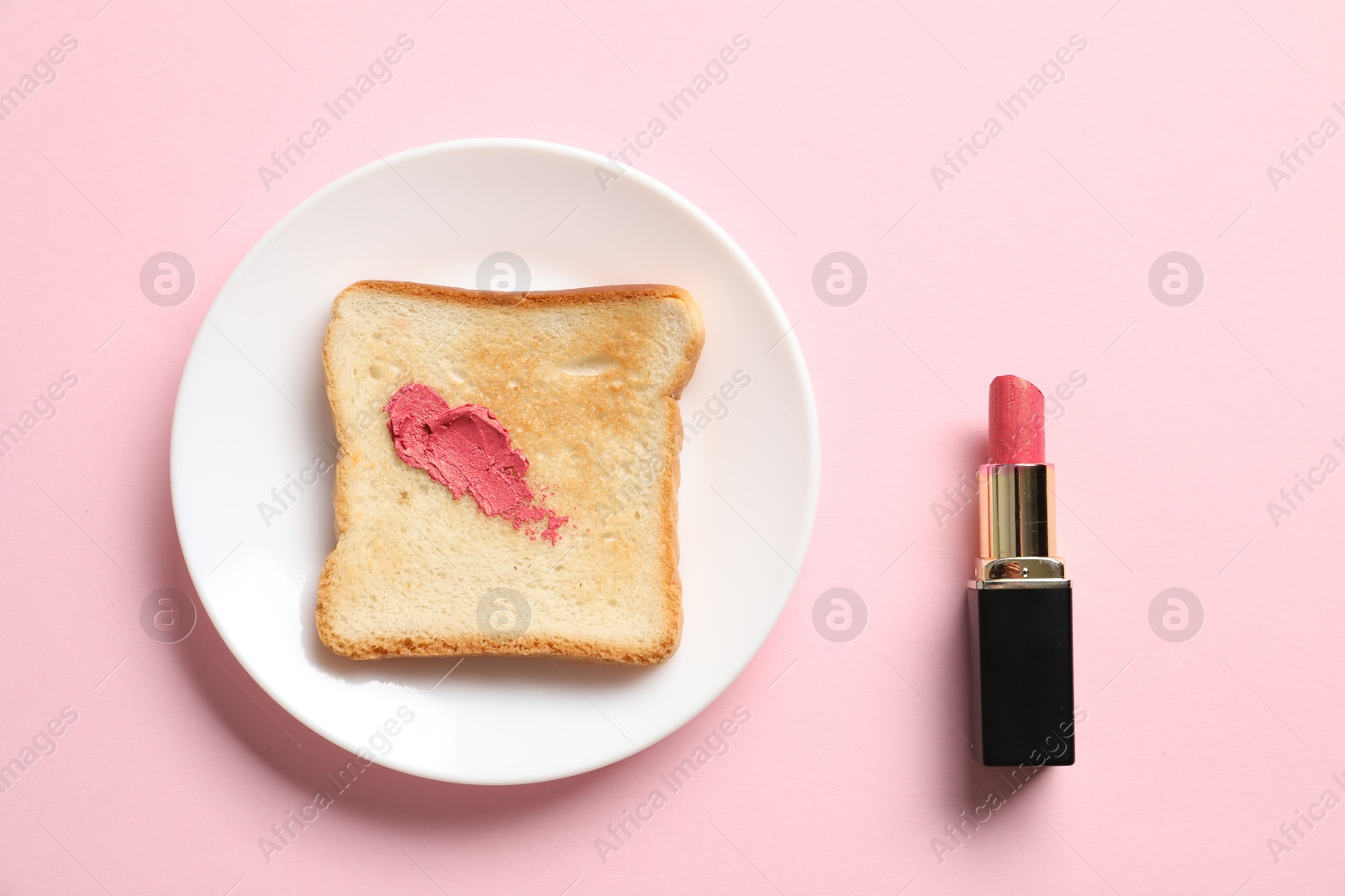 Photo of Toast with lipstick on light pink background, flat lay