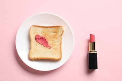 Photo of Toast with lipstick on light pink background, flat lay
