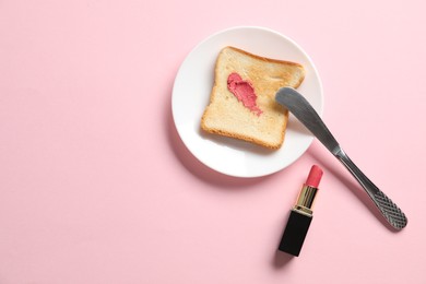 Photo of Toast with lipstick and butter knife on light pink background, flat lay. Space for text