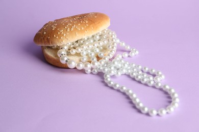 Photo of Burger with pearl necklace on lilac background, closeup