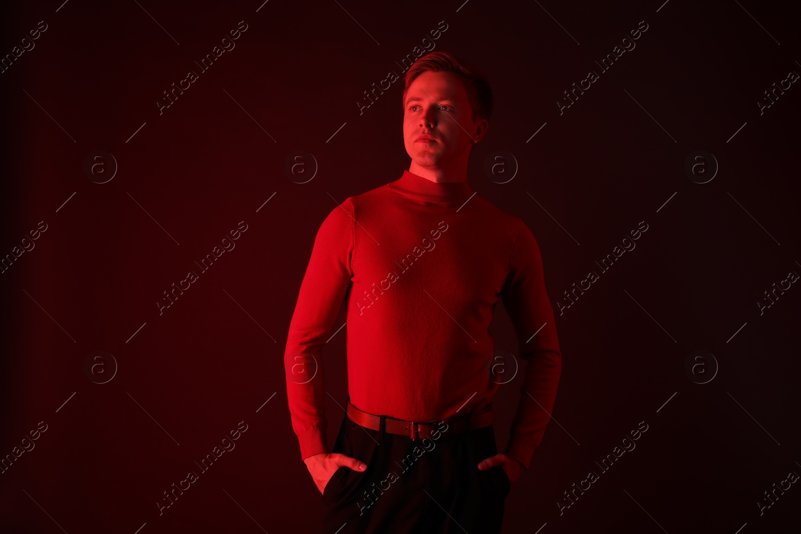 Handsome man in neon lights against dark background Photo of Handsome man in neon lights against dark background