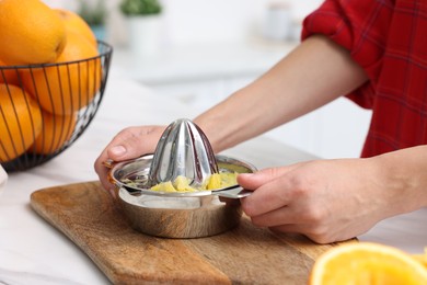 Photo of Making orange juice. Woman with juicer at white marble table indoors, closeup