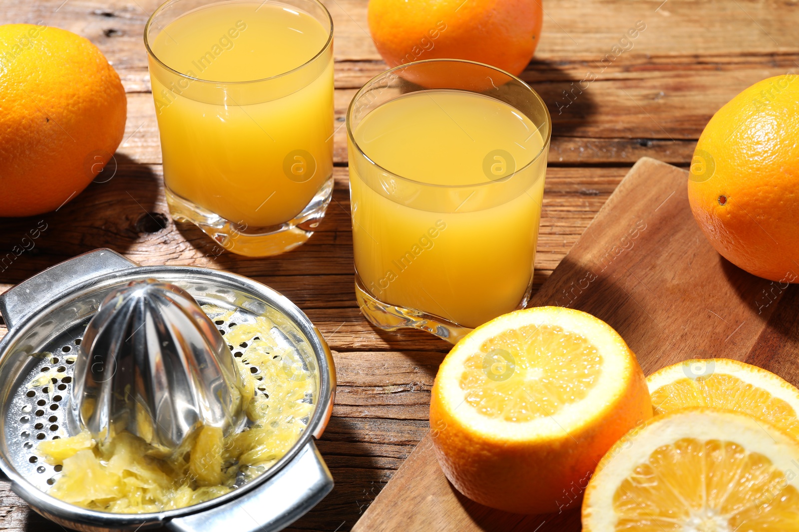 Freshly squeezed orange juice, fruits and juicer on wooden table, closeup Photo of Freshly squeezed orange juice, fruits and juicer on wooden table, closeup