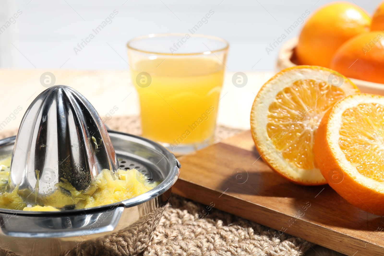 Freshly squeezed orange juice, fruits and juicer on table, closeup Photo of Freshly squeezed orange juice, fruits and juicer on table, closeup