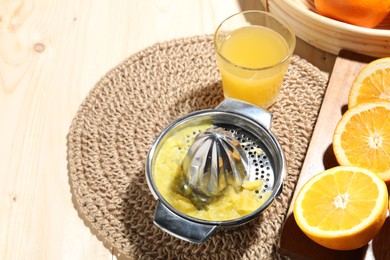 Photo of Freshly squeezed orange juice, fruits and juicer on wooden table, above view. Space for text