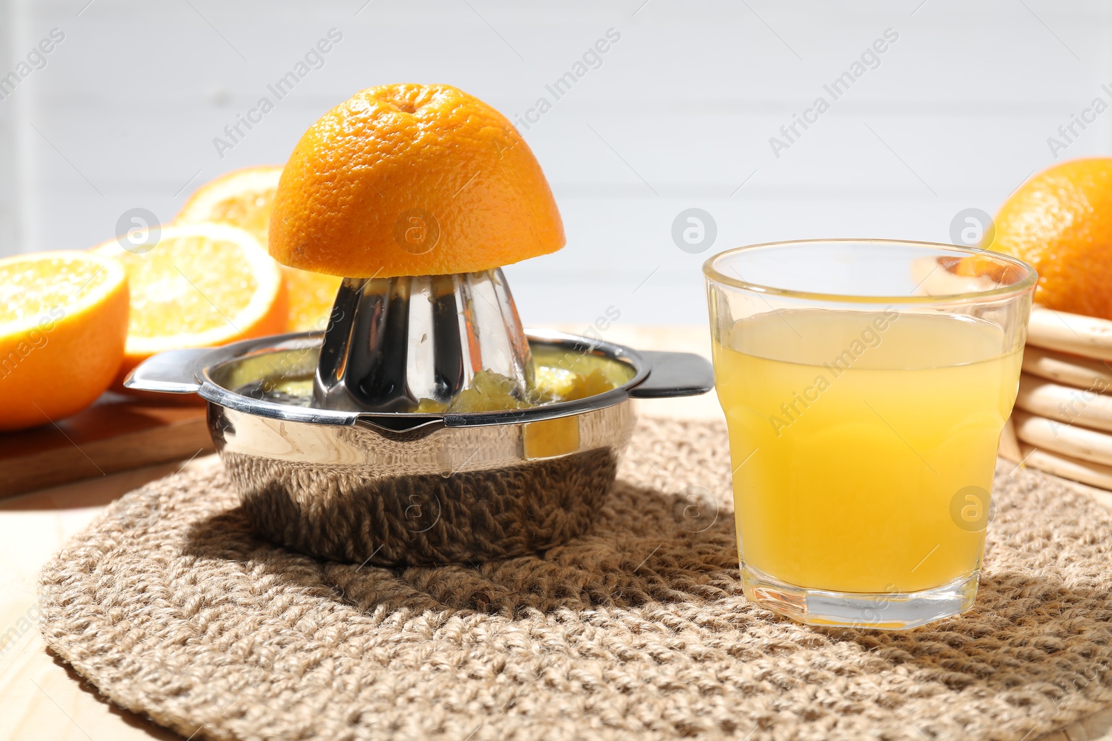 Freshly squeezed orange juice, fruits and juicer on table, closeup Photo of Freshly squeezed orange juice, fruits and juicer on table, closeup