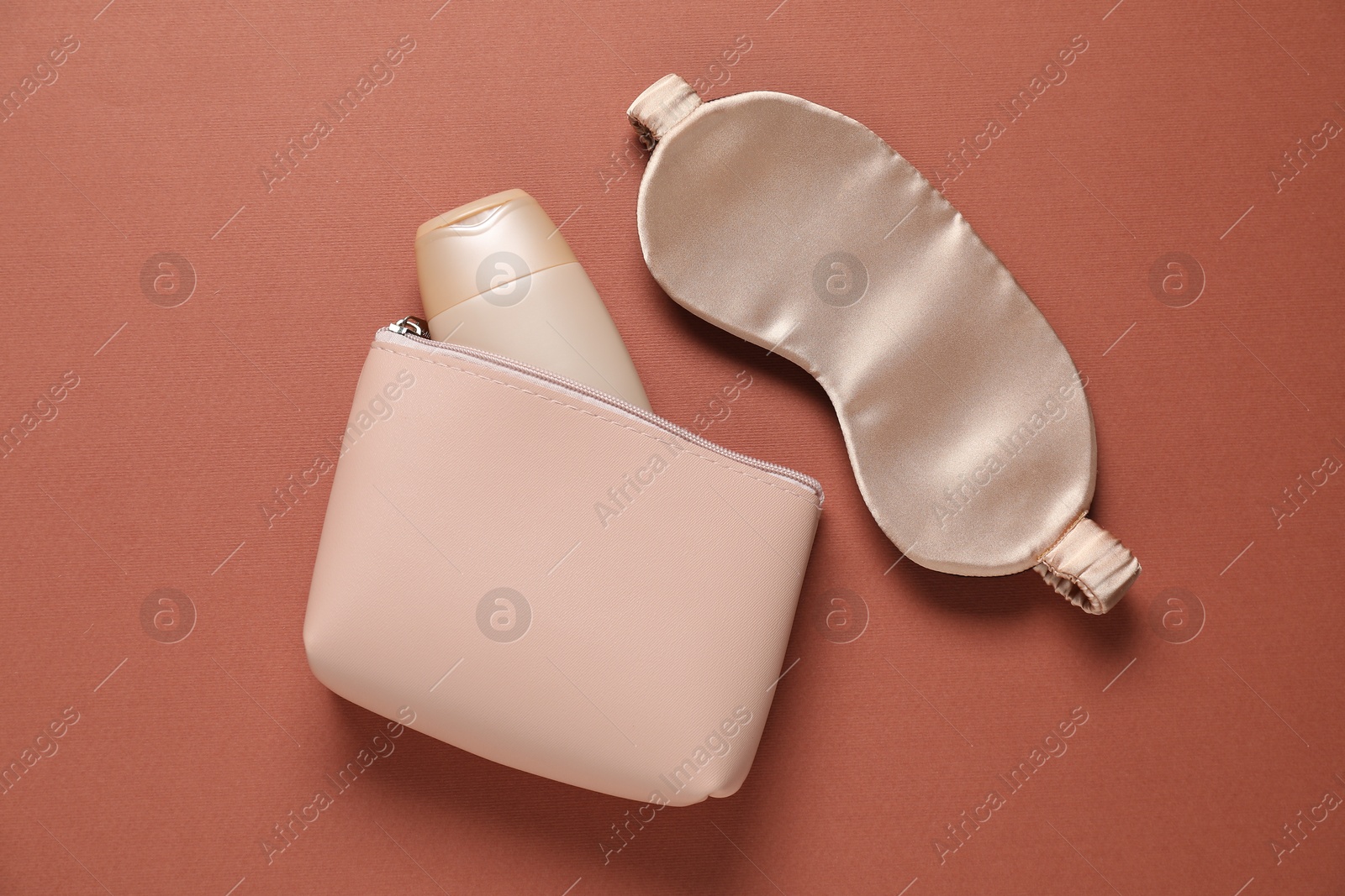 Bag with cosmetic product and sleeping mask on brown background, flat lay Photo of Bag with cosmetic product and sleeping mask on brown background, flat lay