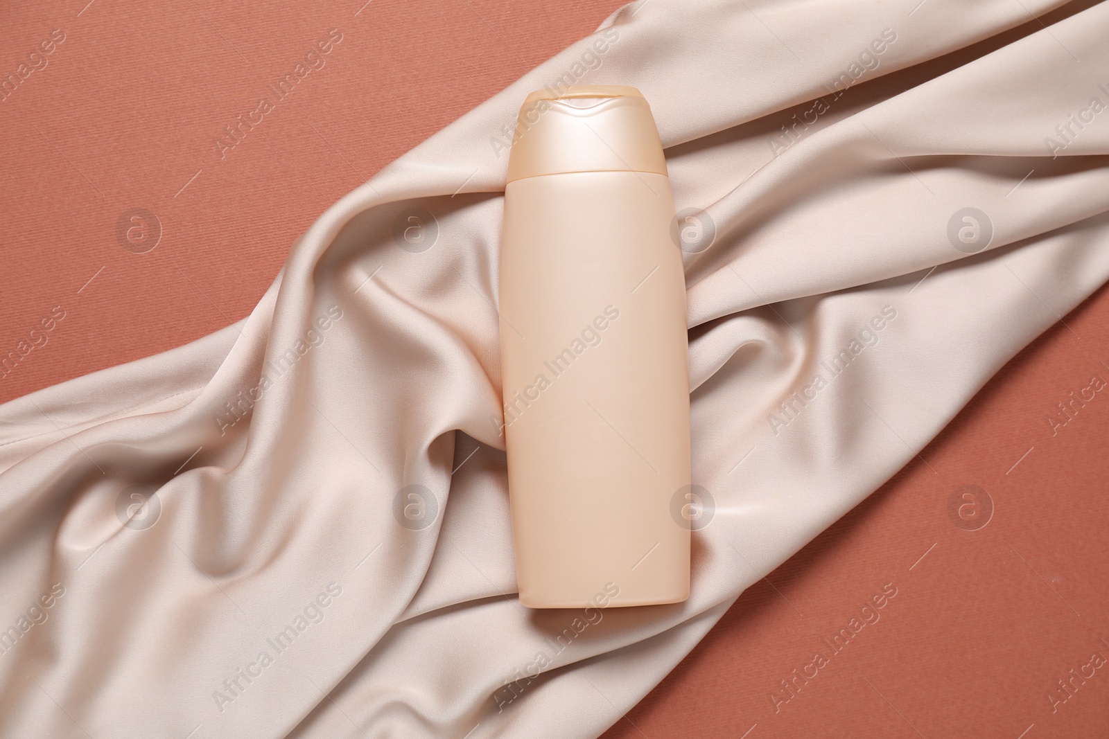 Cosmetic product and fabric on brown background, top view. Mockup for design Photo of Cosmetic product and fabric on brown background, top view. Mockup for design