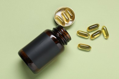 Photo of Jar of vitamins on light green background, top view