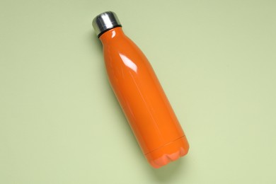Photo of Water bottle on light green background, top view