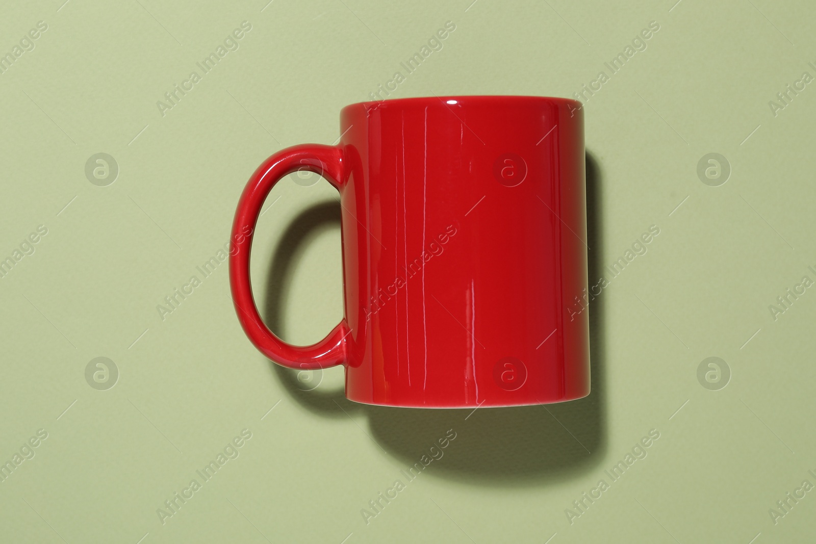 Red mug on light green background, top view. Mockup for design Photo of Red mug on light green background, top view. Mockup for design