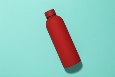Photo of Water bottle on turquoise background, top view