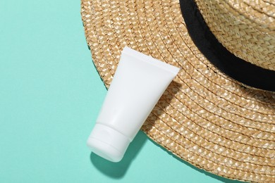 Photo of Cosmetic product and hat on turquoise background, closeup. Mockup for design