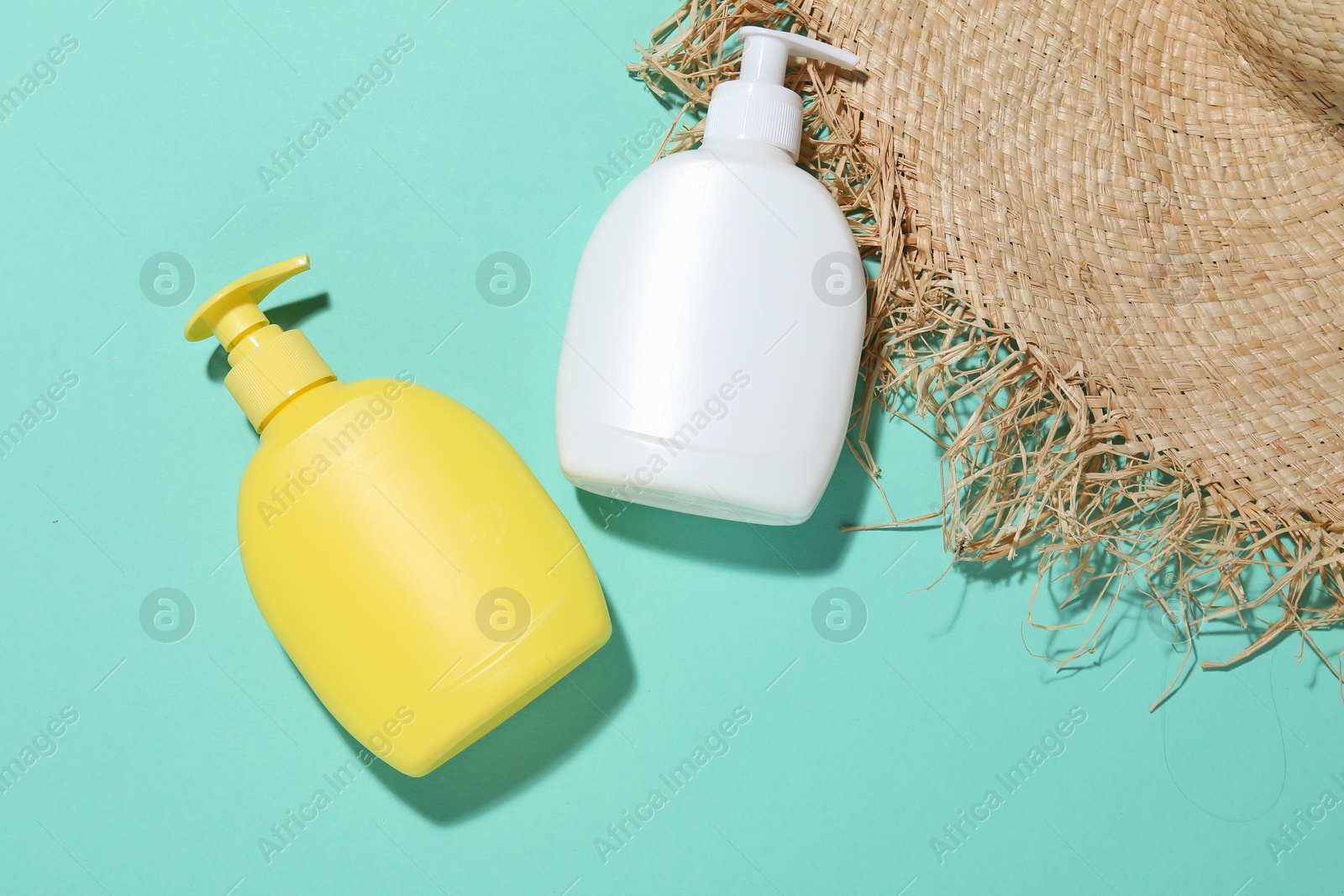Cosmetic products and hat on turquoise background, flat lay. Mockup for design Photo of Cosmetic products and hat on turquoise background, flat lay. Mockup for design