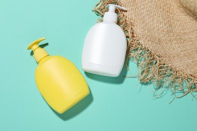 Photo of Cosmetic products and hat on turquoise background, flat lay. Mockup for design