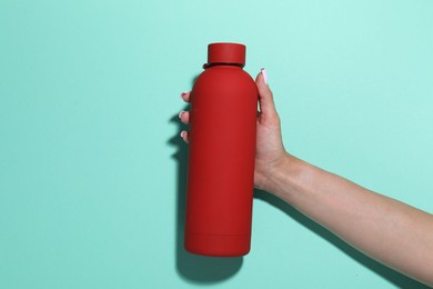 Photo of Woman with water bottle on turquoise background, closeup