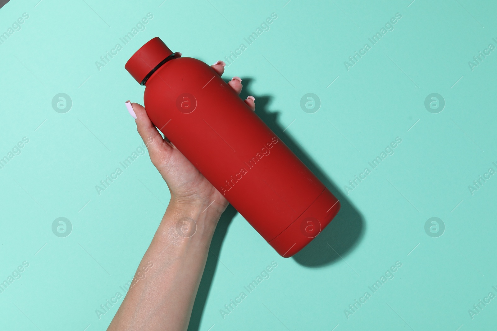 Woman with water bottle on turquoise background, closeup Photo of Woman with water bottle on turquoise background, closeup