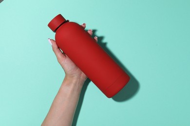 Photo of Woman with water bottle on turquoise background, closeup