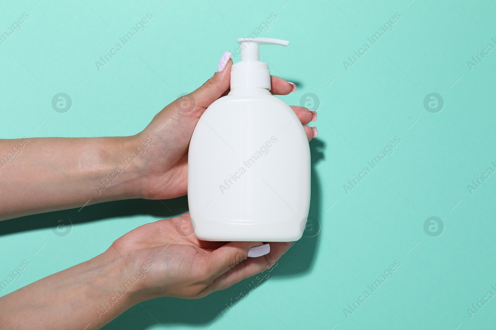 Woman with cosmetic product on turquoise background, closeup. Mockup for design Photo of Woman with cosmetic product on turquoise background, closeup. Mockup for design