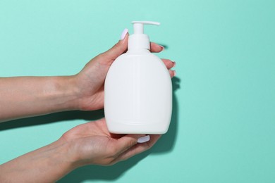 Photo of Woman with cosmetic product on turquoise background, closeup. Mockup for design