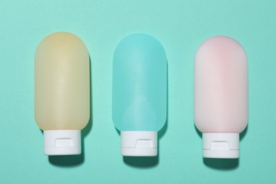 Photo of Cosmetic products on turquoise background, flat lay. Mockup for design