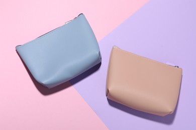 Photo of Cosmetic bags on color background, flat lay