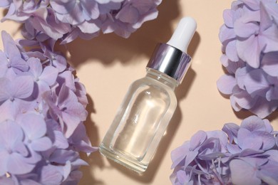 Photo of Cosmetic product and flowers on beige background, flat lay. Mockup for design