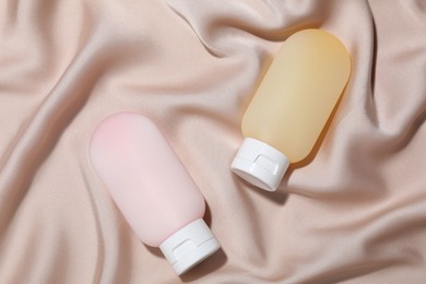 Photo of Cosmetic products on beige fabric, top view. Mockup for design
