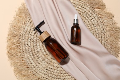 Photo of Cosmetic products, wicker mat and fabric on beige background, flat lay. Mockup for design