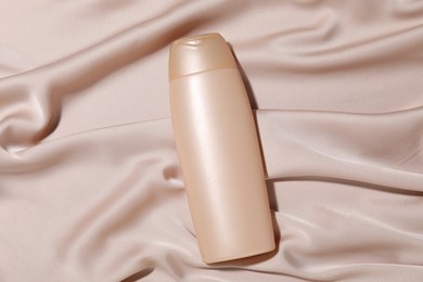 Photo of Cosmetic product on beige fabric, top view. Mockup for design