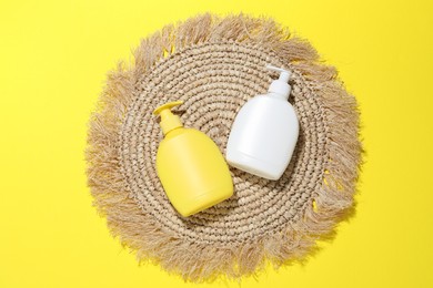 Photo of Cosmetic products and wicker mat on yellow background, flat lay. Mockup for design