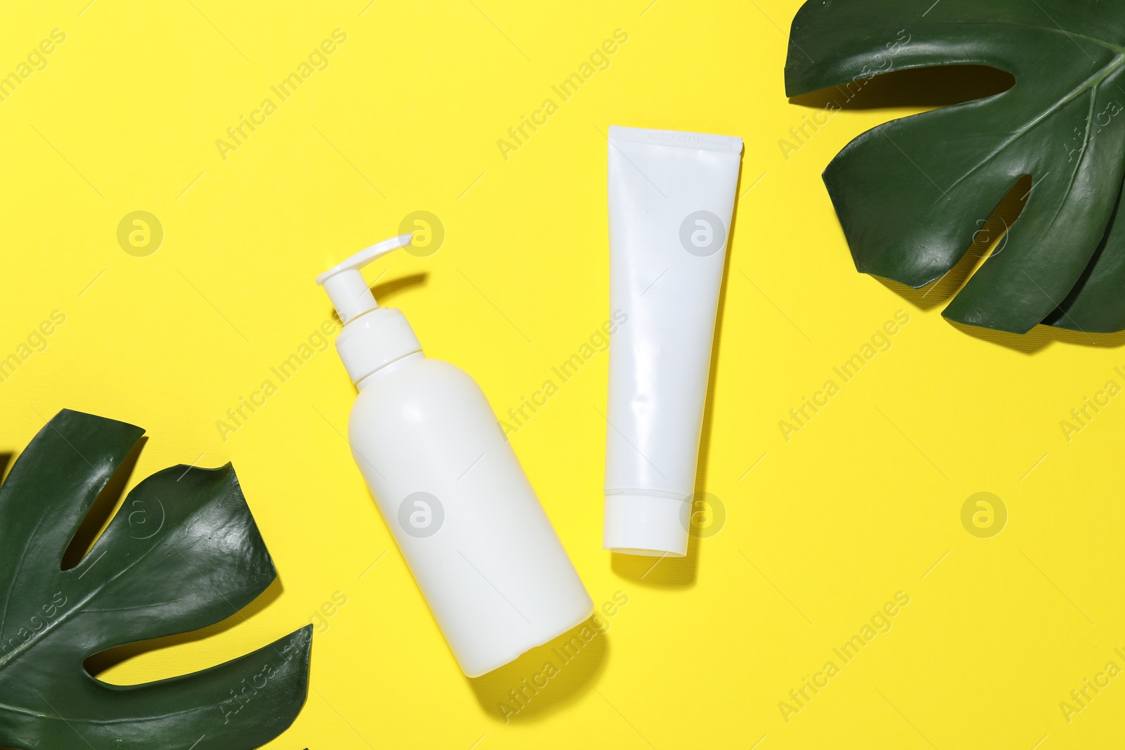 Cosmetic products and leaves on yellow background, flat lay. Mockup for design Photo of Cosmetic products and leaves on yellow background, flat lay. Mockup for design