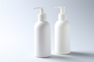 Photo of Bottles of cosmetic products on light background. Mockup for design