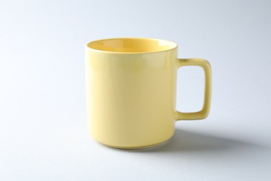 Photo of Yellow mug on light background. Mockup for design