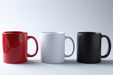 Photo of Mugs on light background. Mockup for design