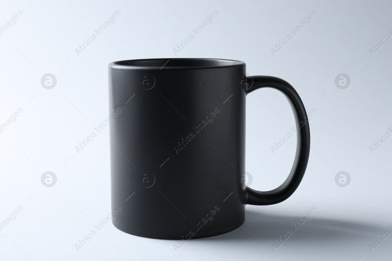 Black mug on light background. Mockup for design Photo of Black mug on light background. Mockup for design
