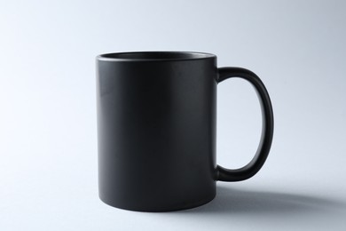 Photo of Black mug on light background. Mockup for design