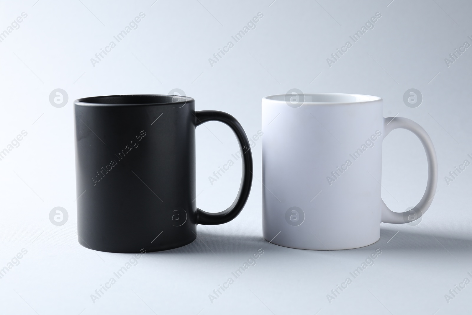Mugs on light background. Mockup for design Photo of Mugs on light background. Mockup for design